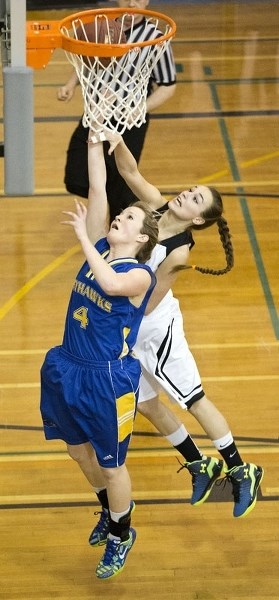 JUMP BALL – Jamie Bain of the St. Albert Skyhawks and Britney Hinecker of the Paul Kane Blues leap for ball in the first half of the Battle of St. Albert on Monday at Paul