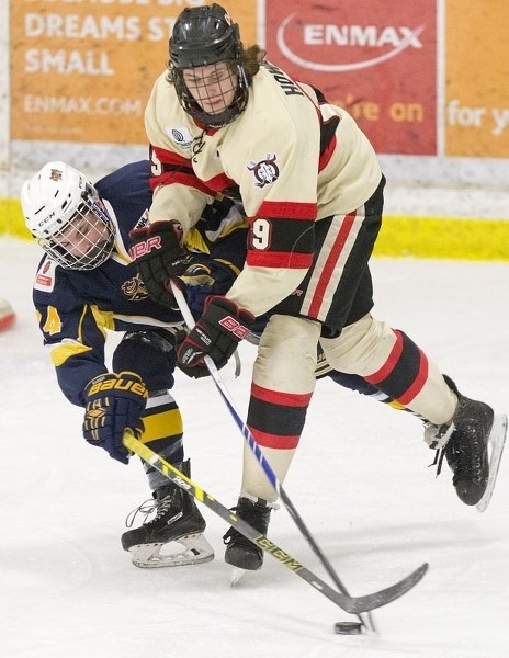 STICK CHECK – Brayden Nicholetts of the St. Albert Raiders goes for the puck against Ryley Smith of the Red Deer Chiefs in Sunday&#8217;s midget AAA game at Akinsdale Arena.