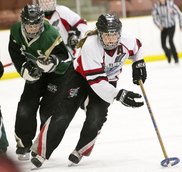 RING RUSHER &#8211; Taylor Ostafichuk of the St. Albert Mission junior U16AA team pulls away from the Spruce Grove belle U19A player in Sunday&#8217;s exhibition at Go Auto