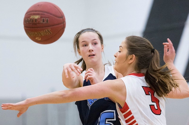 FLYING OBJECT – Jenell Desharnais of the Paul Kane Blues fires a pass while guarded by Paige Lakeman of the Jasper Place Rebels in Saturday&#8217;s consolation final at the