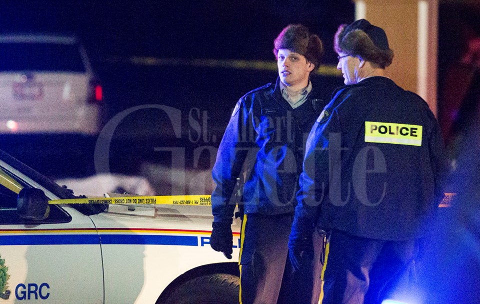 RCMP officers converse at a crime scene on Monday night at the Nevada Place apartments in St. Albert. The subject was a 25 year old male.