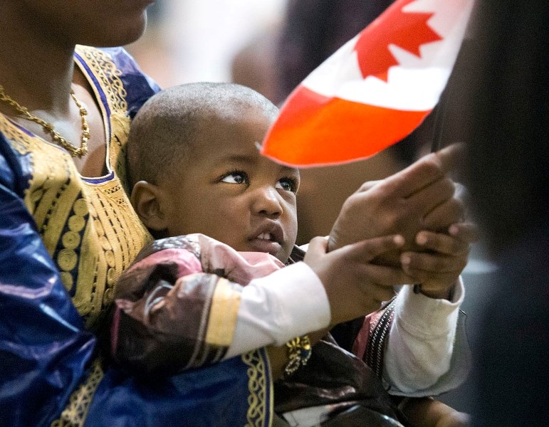 YOUNG CANADIAN &#8211; Souleymane Bah waves a flag at her citizenship ceremony on Friday morning at Muriel Martin Elementary School. The ceremony marked an end to the process 