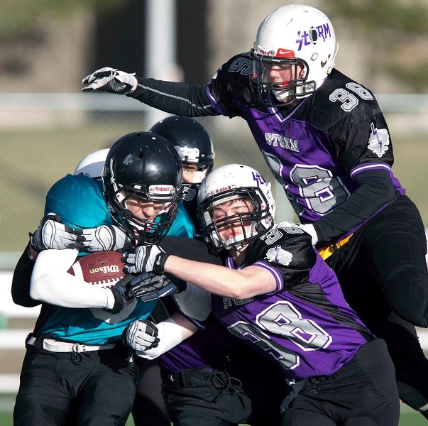 STORMING TO THE BALL – Damen Murley of the St. Albert Storm latches onto Logan Sadowsky of the Parkland Predators