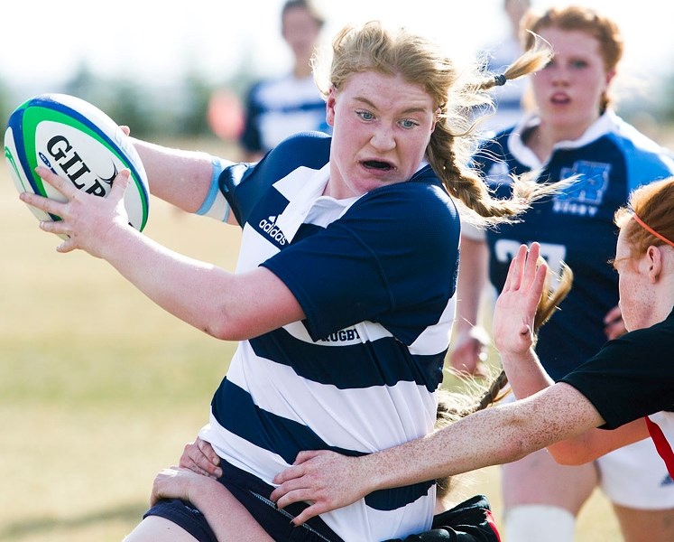 RUGBY ROMP – Sydney De La Mare of the Paul Kane Blues controls the ball while Georgia Nixon and the Sturgeon Spirits attempt to stop the Grade 11 eight-man in Tuesday&#8217;s 