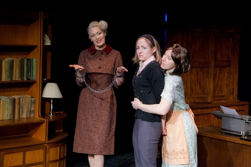 Series writer Eleanor Innes (Linda Grass) handles a pair of shackles while Penelope (Lianna Shannon) restrains young writer Judy Parker (Jenna Dykes-Busby) in Shadow