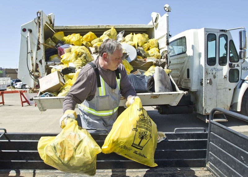 RIVERFEST — City employee Bill Gamborski helps load up the garbage truck after collecting the garbages bags residents collected along the river Sunday during the 2014 Clean