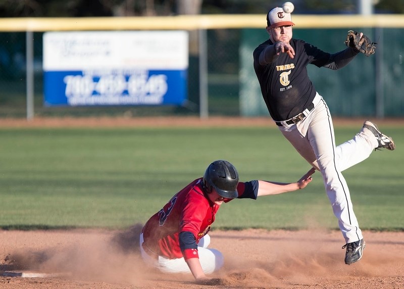 PLAYMAKER – Kyle Hesse of the senior AAA St. Albert Tigers fires the ball to first base while avoiding a sliding Tyler Shwendeman of the midget AAA St. Albert Cardinals in