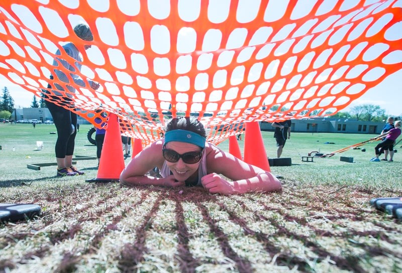 Gazette reporter Michelle Ferguson completes an army crawl during an obstacle race training class hosted by St. Albert-based Alberta Fitness.