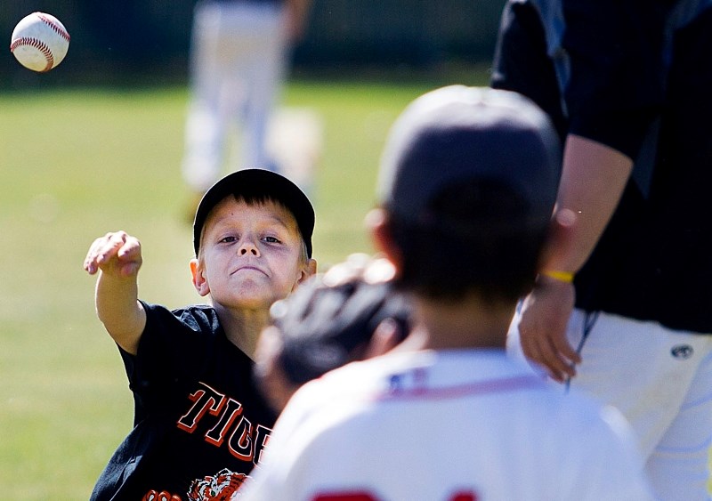PLAYING CATCH &#8211; Seven-year-old Jordan Nikiforuk tosses the ball around with his partner during the annual St. Albert Tigers Camp for male and female rally cap to peewee 