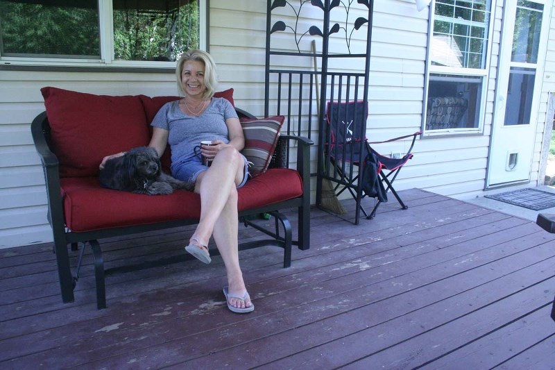 LOUNGING – Deborah Donick on the deck of the St. Albert home she hopes to give away through an essay contest.