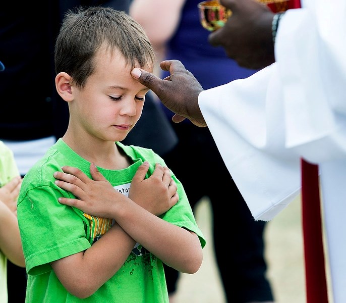 BLESSED – Neil M. Ross student Tristan Hayward receives a blessing during the Catholic Mass on the Hill event on Thursday at Mission Hill. Thousands of students were in