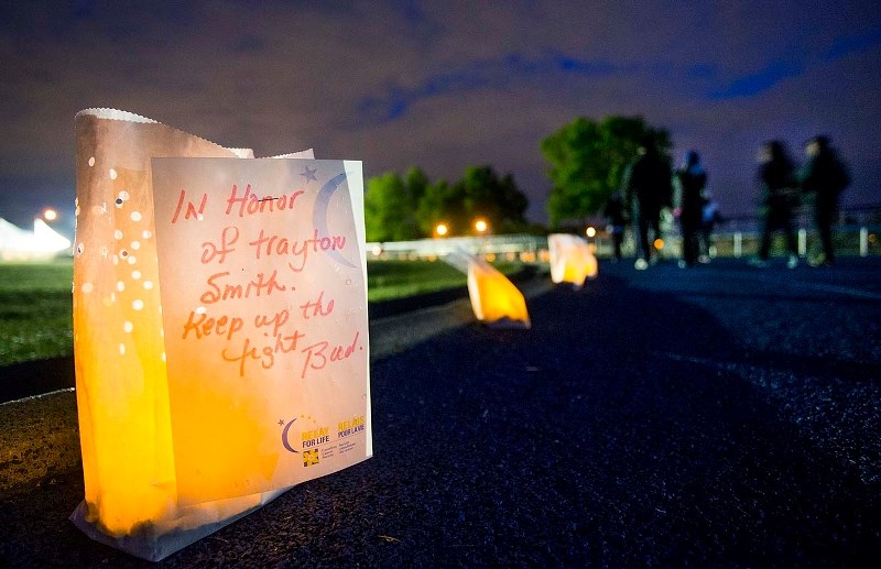 WALKING FOR A CURE &#8211; A somber note pinned to a candle lights the path while participants walk the track at Fowler Athletic Park late on Saturday night during a twelve