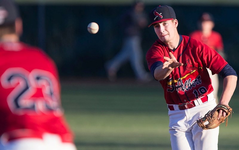 PEGGING THE BALL – Jake Fischer of the St. Albert Cardinals throws to first-baseman Erik Sabrowski during a game in the NorWest Midget AAA Baseball League. The 2014 Baseball