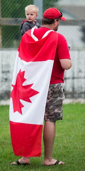 PATRIOTISM &#8211; A young boy and his Dad wait in line at the pancake breakfast during the Canada Day festivities on Wednesday at école La Mission.