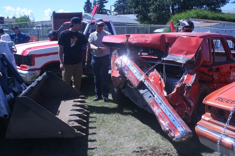 &quot;SHE&#8217;S PRETTY FOLDED&quot; – Matt Prefontaine (left) and his dad Mitch examine the damage to Matt&#8217;s 1986 Lincoln Continental after one round of a demolition