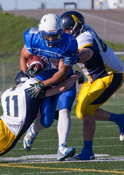 BREAKTHROUGH &#8211; Taylor Simmons of the St. Albert Stars busts through a pair of Grande Prairie Drillers in the Alberta Football League playoffs Saturday. The Stars scored 