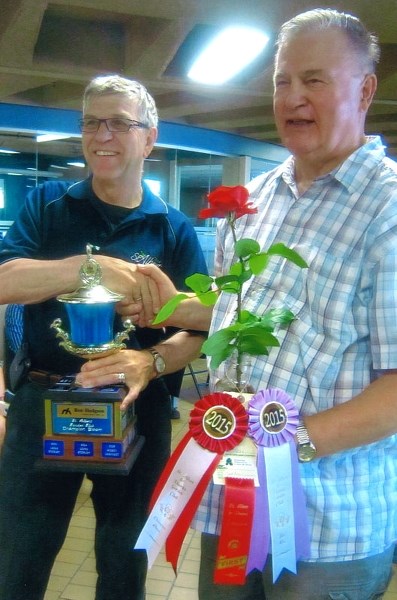 Mayor Nolan Crouse presents former mayor Richard Plain with the trophy for Champion Bloom of the show – a tea rose.