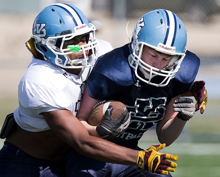GRIDIRON BLUES – Isaiah Ansah tackles Connor Smith at the Paul Kane Blues&#8217; fall camp at Riel Recreation Park. The undefeated Miles division two champions the last two