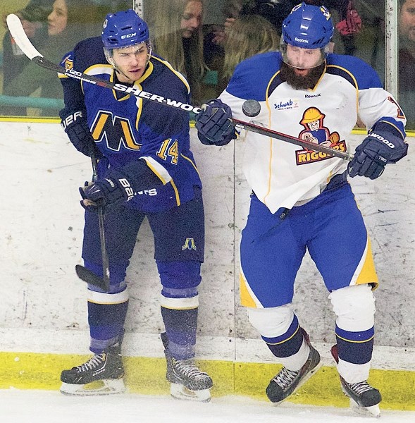 PLAYING THE PUCK – Mike Bruni of the St. Albert Merchants and Darren Bourassa of the Leduc Riggers eye up the flying puck during junior B action last season at Akinsdale