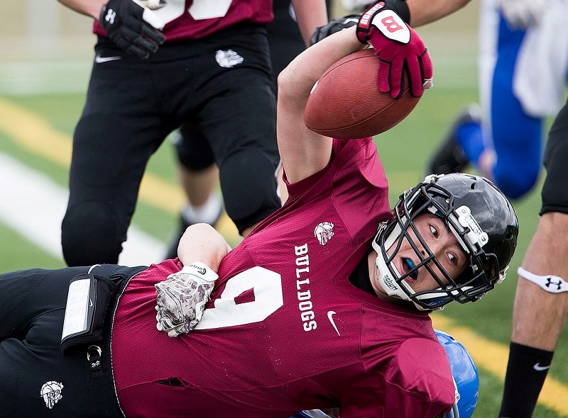 DAWG COLLARED &#8211; Keanin Paziuk of the Bellerose Bulldogs is tackled in Saturday&#8217;s junior exhibition against the Peace Wapiti Academy Titans of Grande Prairie.