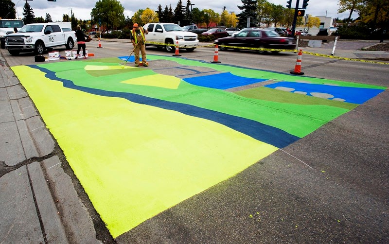 COLOURFUL CROSSWALK – Construction workers apply the second coat of paint to the mural on St. Anne Street