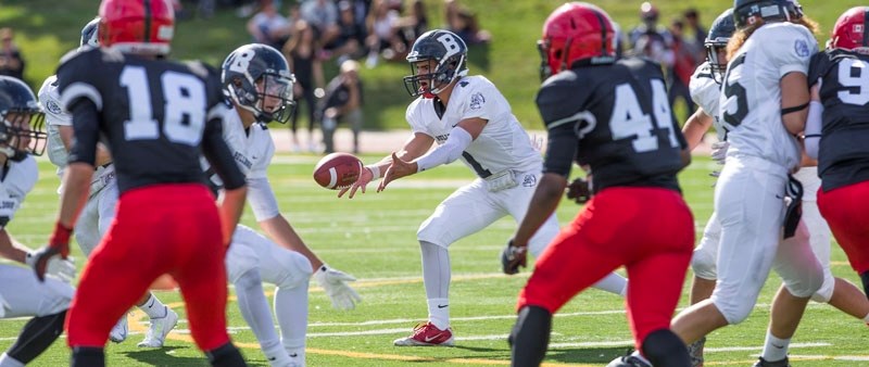 RUNNING PLAY – Morgan Sherban looks to hand off the ball as the Bellerose Bulldogs provide the blocking up front in Friday&#8217;s 24-22 win over the Jasper Place Rebels at