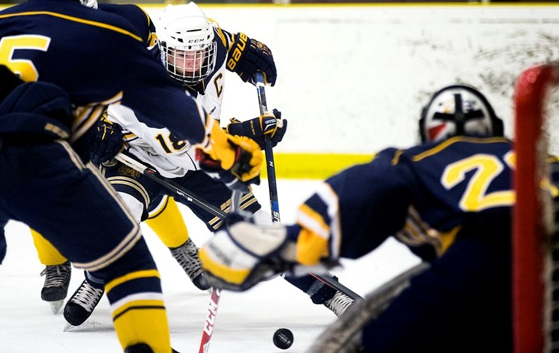 GOING FOR GOAL – St. Albert Blues captain Sam Smith-Ackerl attacks the net against defenceman Tyler Schnirer and goalie Elliot Saive of the St. Albert Crusaders in