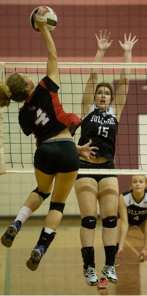 DEFENDING THE NET – Megan Forster throws up a block with Kristen Kolthof providing defensive support for the Bellerose Bulldogs against Lauren Halldorson of the Sturgeon
