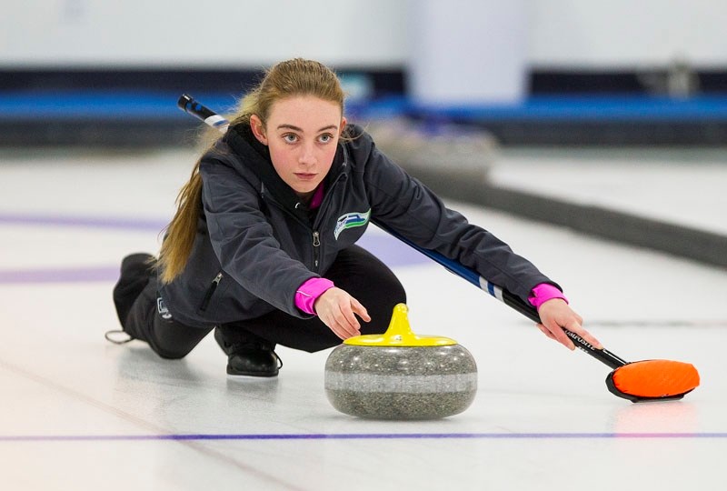 GOING TO THE GAMES – Brennin Turner delivers a rock while Andrew McLeod holds the broom in doubles&#8217; curling at the Alberta Winter Games&#8217; pre-event open bonspiel