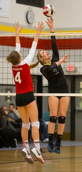 SHOT MAKER – Jamie Bain of the St. Albert Skyhawks strikes the volleyball as Mandy Behiels of the Jasper Place Rebels defends the net in Saturday&#8217;s metro Edmonton
