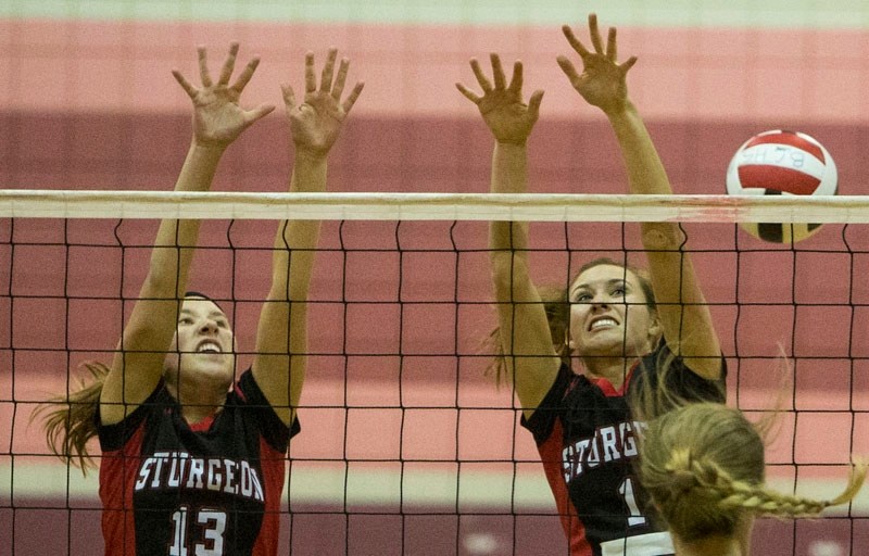 BLOCKERS – Kendra Fincaryk (13) and captain Rian Perrott throw up blocks for the Sturgeon Spirits