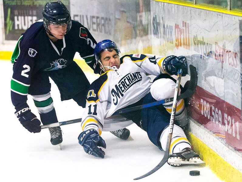 UPENDED – Thomas Rotundo of the St. Albert Merchants goes for a spill while checked by Andrew Clark of the Edmonton Mustangs in Friday&#8217;s junior B game at Akinsdale