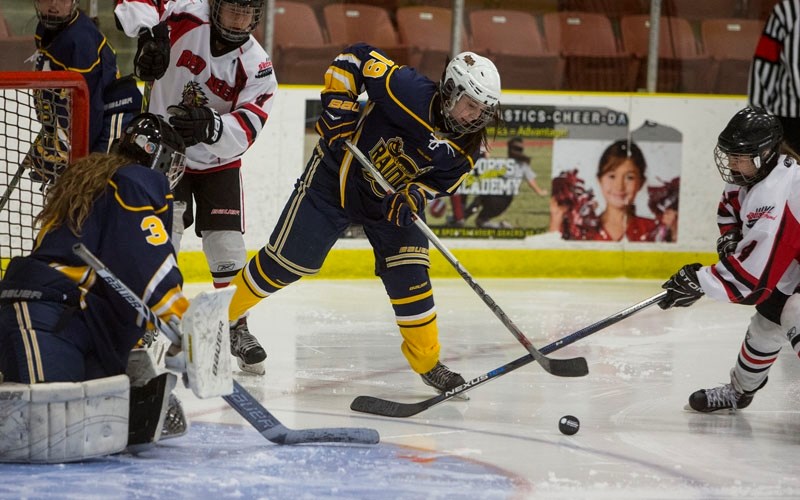 GAME ON FOR WINTER GAMES – Emma Sundar of the St. Albert Lady Raiders plays the puck in front of netminder Elle Boyko for the St. Albert Lady Raiders during a recent home
