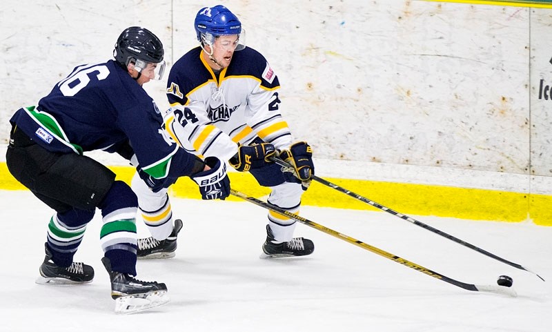 PUCK CHALLENGE â€“ Casey Reid plays the puck against Matthew Cantalini of the Edmonton Mustangs in the St. Albert Merchants&#8217; last home game before the Christmas break