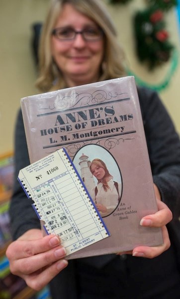 Customer services manager Kathleen Troppmann shows off the hardcover copy of Lucy Maud Montgomery&#8217;s book Anne&#8217;s House of Dreams. It was taken out 38 years ago and 