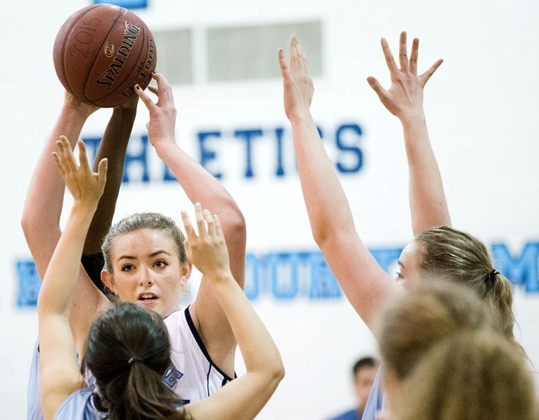 UP IN ARMS â€“ Deanna Missins of the Paul Kane Blues looks for support while pressured by the St. Joseph Saints in Wednesday&#8217;s metro Edmonton division one contest at