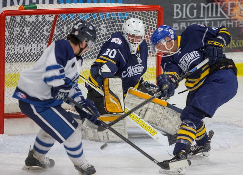 PUCK BATTLE â€“ Mitchell Walters of the St. Albert Merchants hacks away at the puck against Scott Woloshyn of the Morinville Jets in front of netminder Ty Clelland in