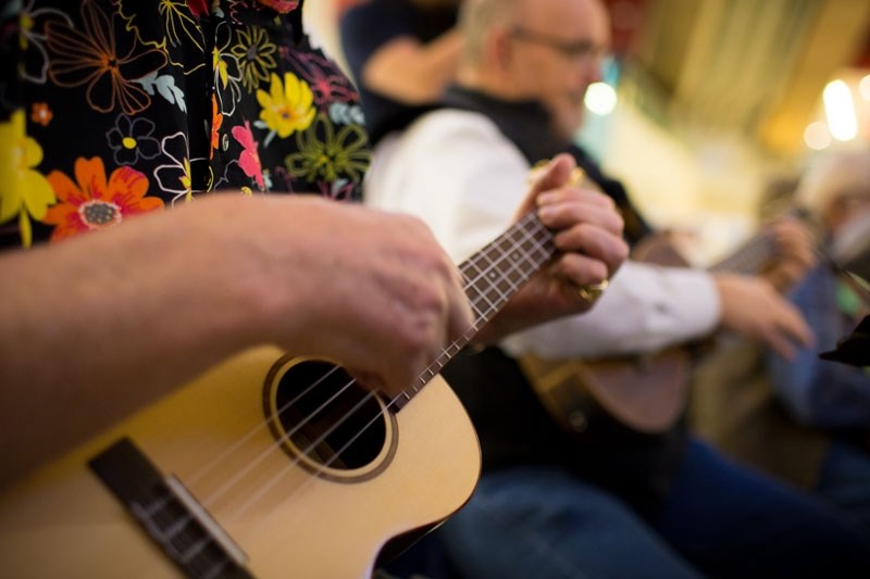 John Boyd strums along with his friends at West Edmonton Mall on Feb. 2.
