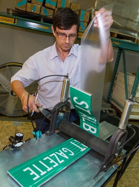 GAZETTE STREET? â€” ATS Traffic employee Terry Cronk puts the finishing touches on a custom street name sign for the St. Albert Gazette. Street name signs use 3M