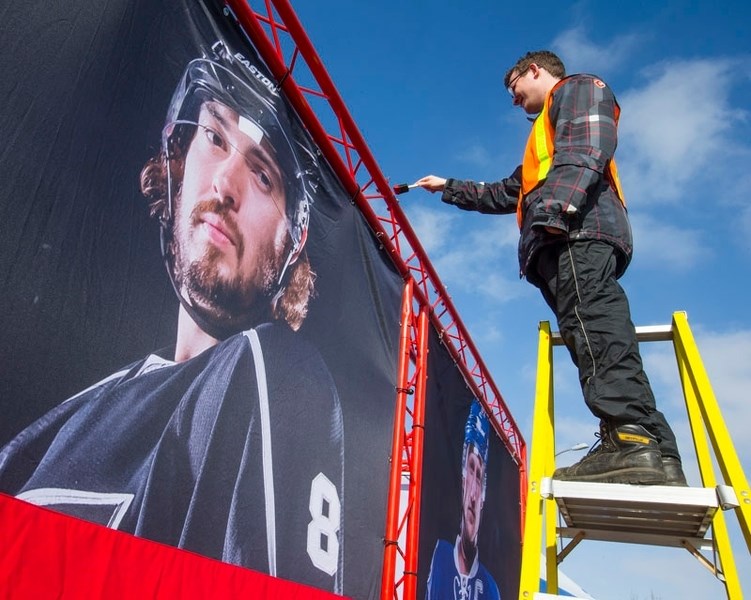 Toronto based SDI Marketing field co-ordinator Graeme Hewson puts some finishing touches on one of the display areas along St. Anne St. for the Hometown Hockey event that