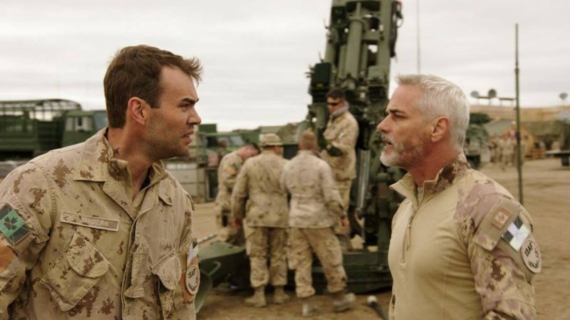 Warrant Officer Ryan Sanders (Rossif Sutherland) discusses his opinion of resolving a tense situation in the Middle East with Captain Pete Mitchell (Paul Gross) in