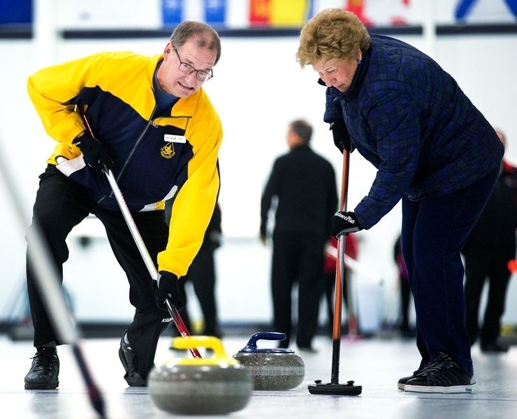 ICE BRUSHERS â€“ Brent Eger and Lee McGillis sweep a rock into the house during the Swiss Chalet 50-plus Mixed Bonspiel that wrapped up last Friday at the St. Albert Curling