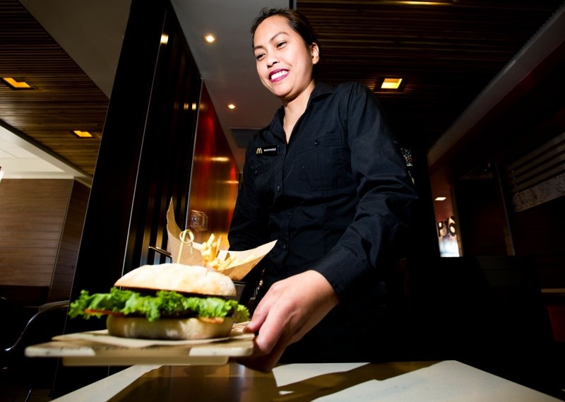 McDonald&#8217;s employee Maryanne Millan serves a customer their food at the central St. Albert McDonald&#8217;s on Tuesday April 5