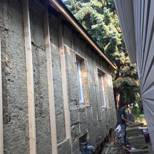 HOT HOUSE â€“ Mike Sanders of Butterwick Construction &amp; Carpentry installs new insulation on Stuart Fix&#8217;s home in Edmonton. Wall insulation upgrades can be very