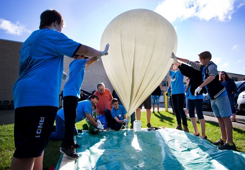 BLOWING UP â€“ Sir George Simpson students steady the SABLE 10 balloon in preparation for launch on Friday June 10. The ongoing weather ballon experiment at the school gives
