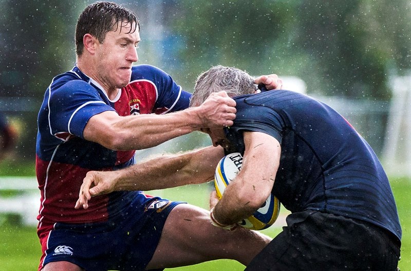 WET AND WILD â€“ Jake Robinson grabs a fist full of jersey while taking down the Clan player in the pouring rain during Saturday&#8217;s Alberta Cup premier men&#8217;s match 