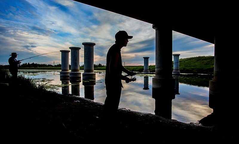 A pair of fisherman cast into the Sturgeon River under the Ray Gibbon Drive overpass late on Thursday evening. Fishing is just one of the activities people can enjoy along