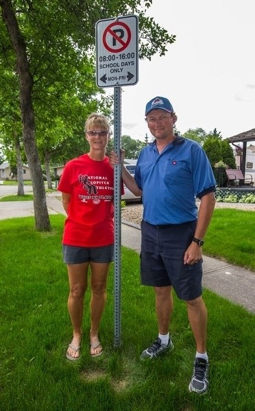 PARKING PROBLEM â€” Michener Place residents John and Lynda Holden indicate one of the no-parking signs on their street. Lynda Holden presented a petition to city council on