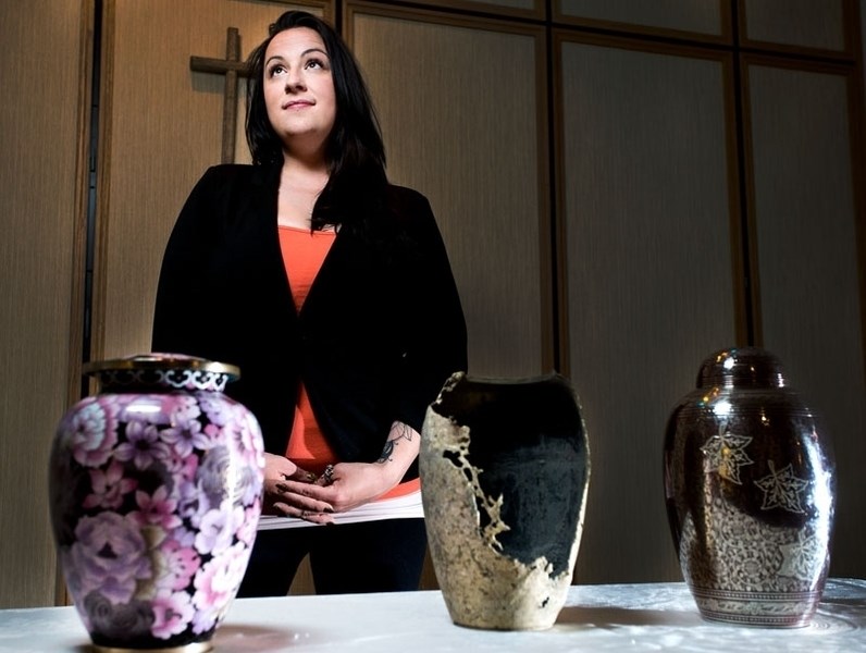 Crystal Kehoe stands with the the urns of both her grandmother and uncle