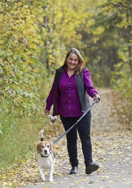 A woman enjoys a walk with her leashed pooch. Morinville residents may have to keep dogs and cats on leash soon.